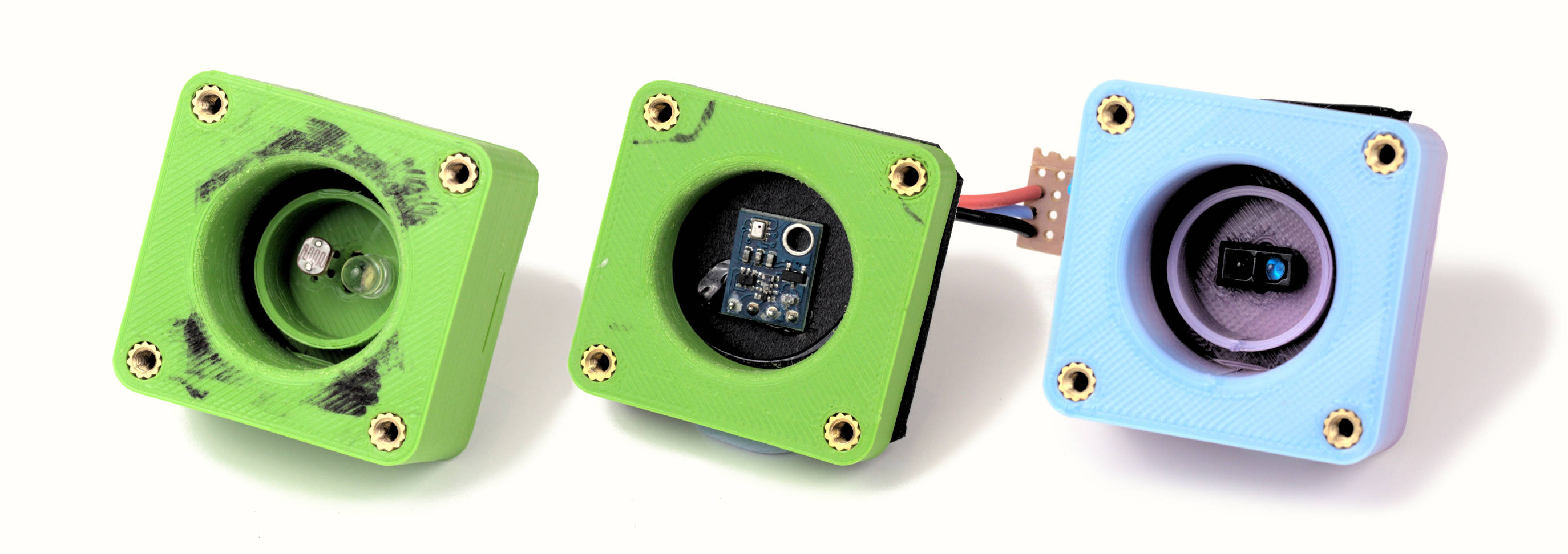 Three square pieces about 4cm across, each with a different sensor in the middle. The left one has an LED and an LDR, the middle has a barometric pressure sensor PCB and the right has a module with an LED and a phototransistor in an LED-like package